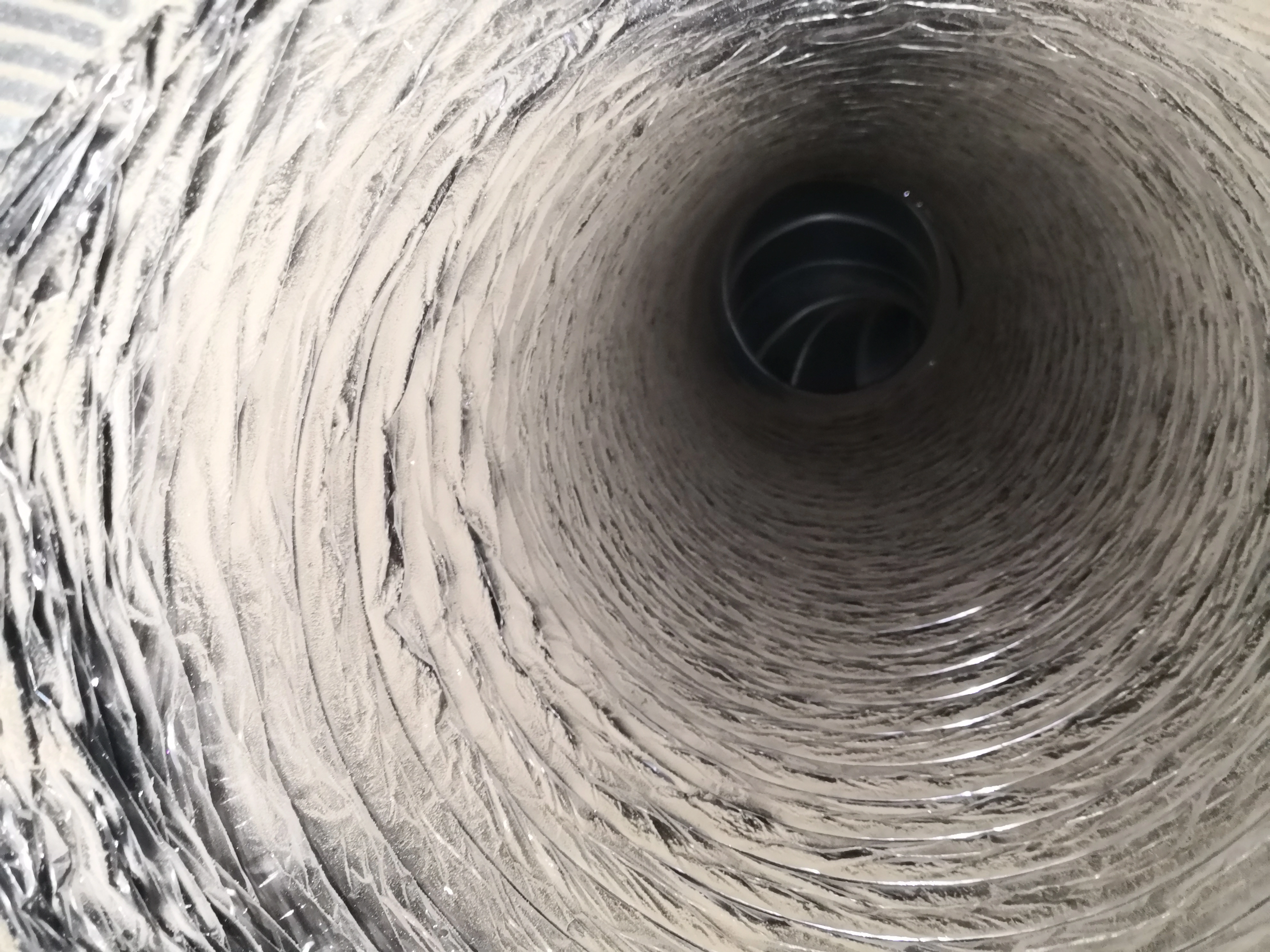 Air duct interior before professional cleaning in Raleigh NC — heavy dust and debris buildup